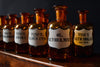 A Collection of Nineteen Amber Apothecary Bottles, Circa 1900.